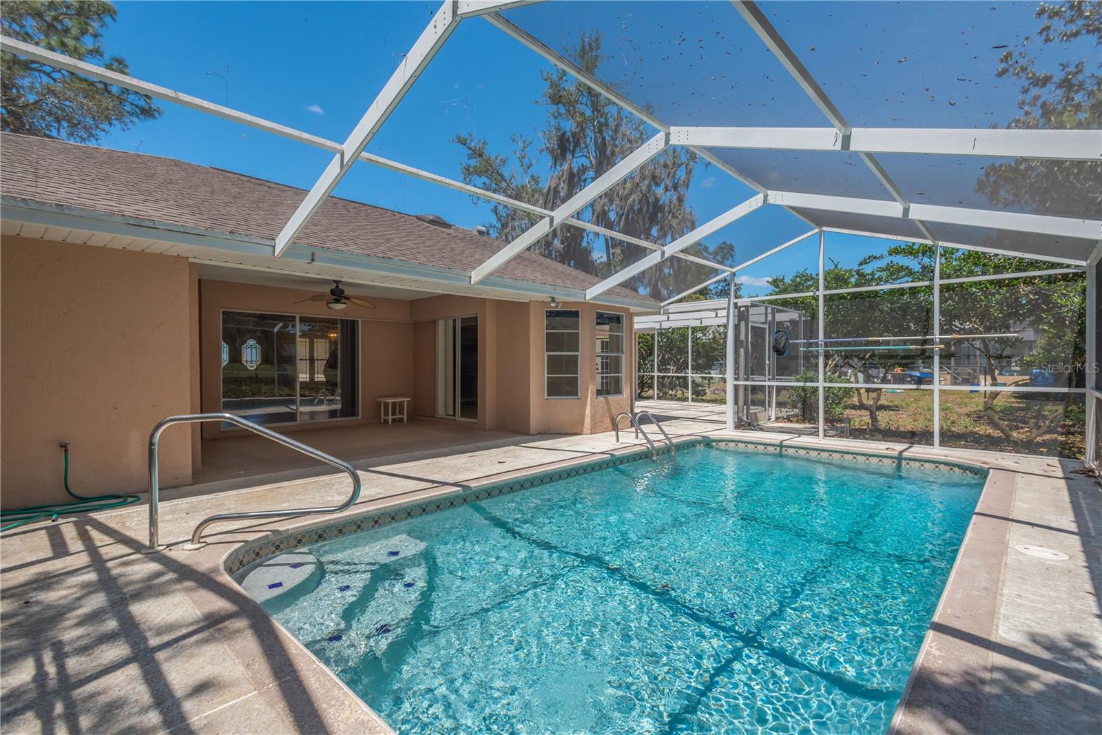 Sparkling pool covered by screen cage.  Great enjoyment on a hot summer's day.