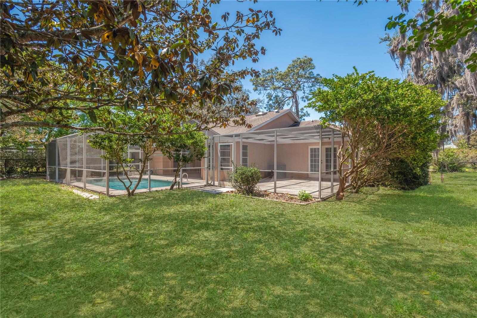Side angle view of backyard, side screen patio and pool/deck.