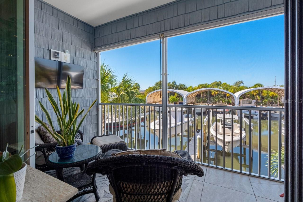 Balcony with a mounted TV and water views.  Enjoy your morning coffee while gazing out at what could be your own ?? boat sitting there waiting for you.