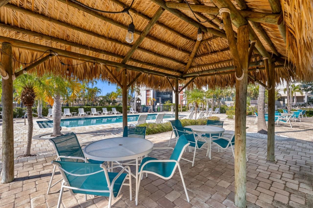 Shaded Tiki seating area next to the pool.