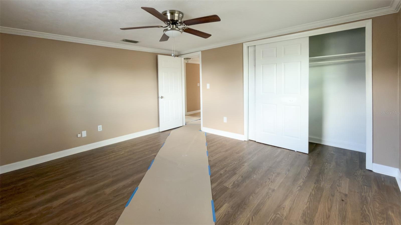 Spacious primary bedroom with abundant natural light and updated flooring.