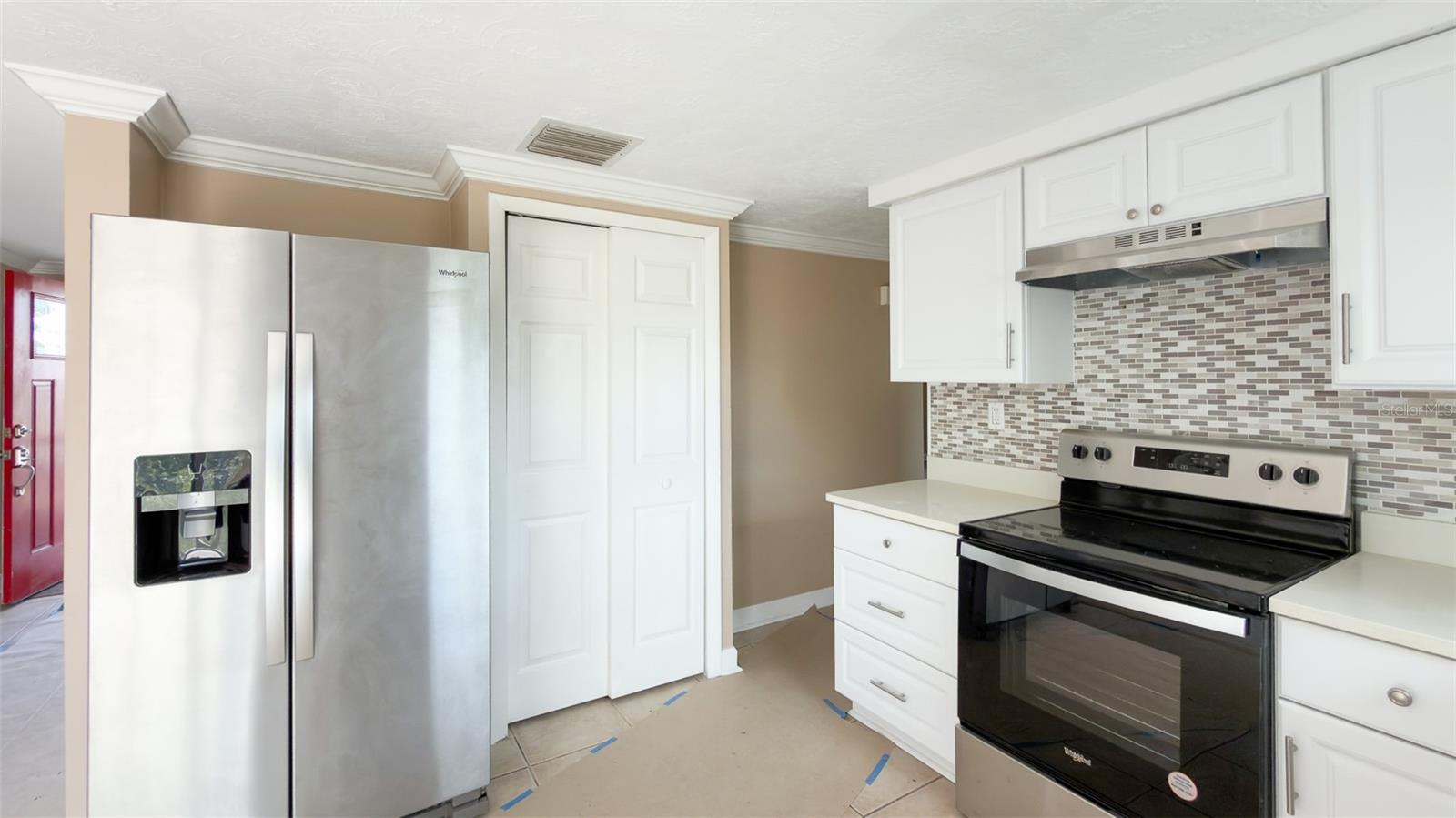 Fully renovated kitchen with white cabinetry and modern quartz countertops.