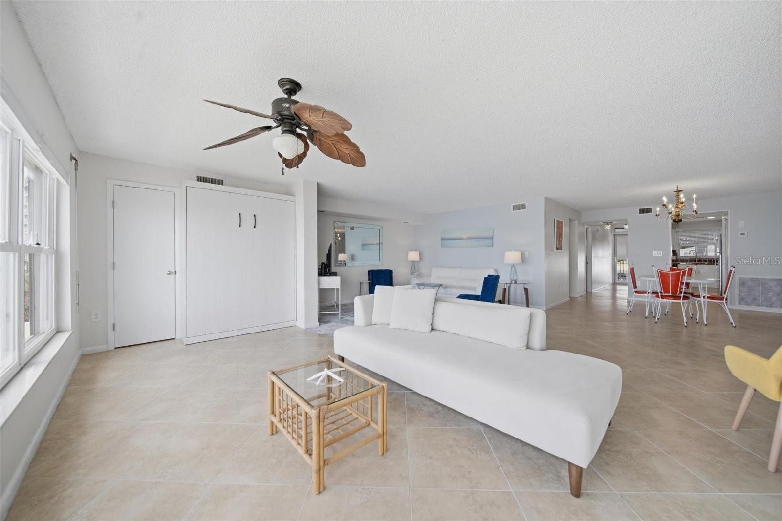 The Murphy bed is concealed with a white elm finish in front of a large storage closet.