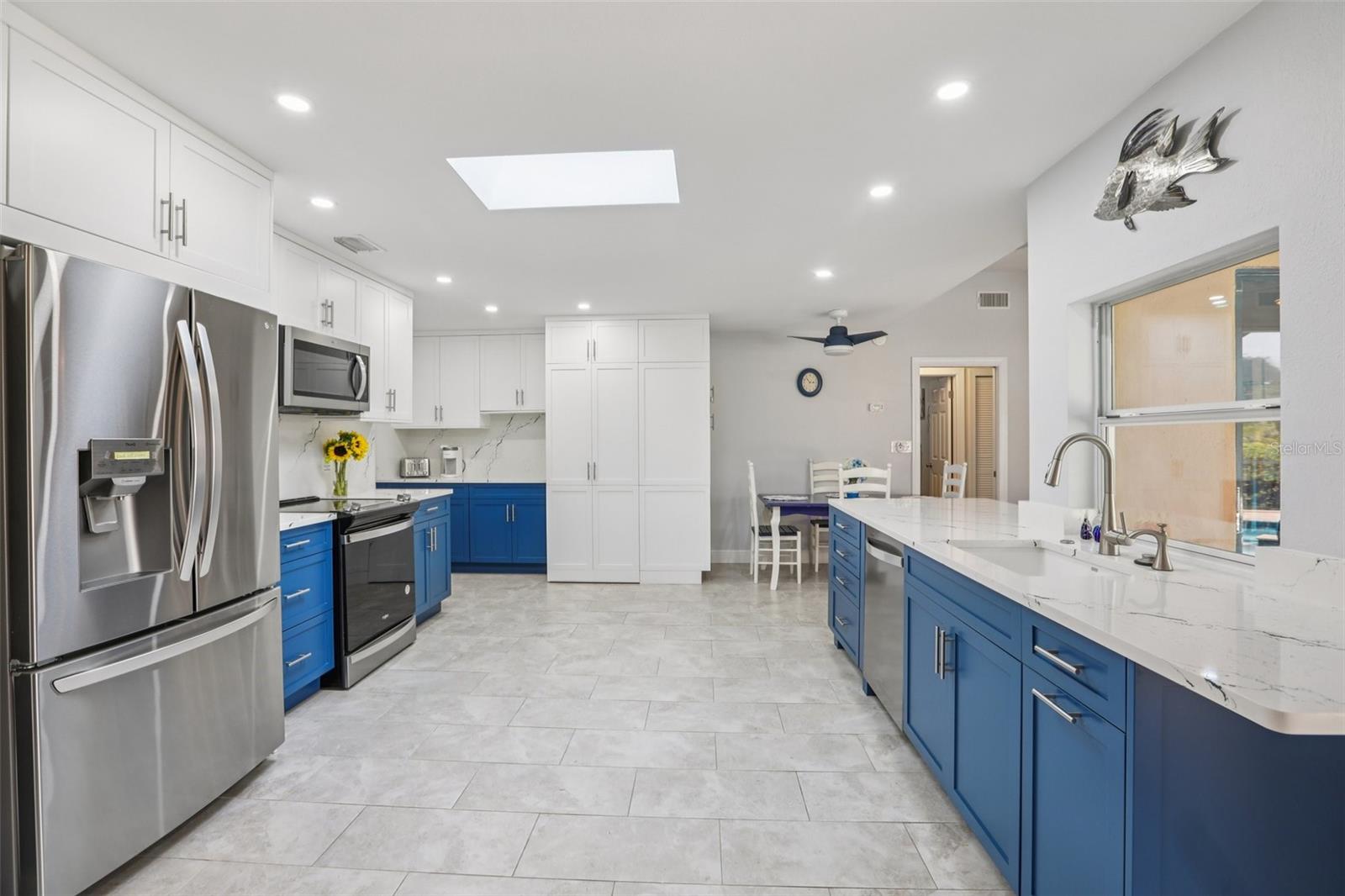 Sun drenched kitchen with its central skylight and pass-through window to the lanai