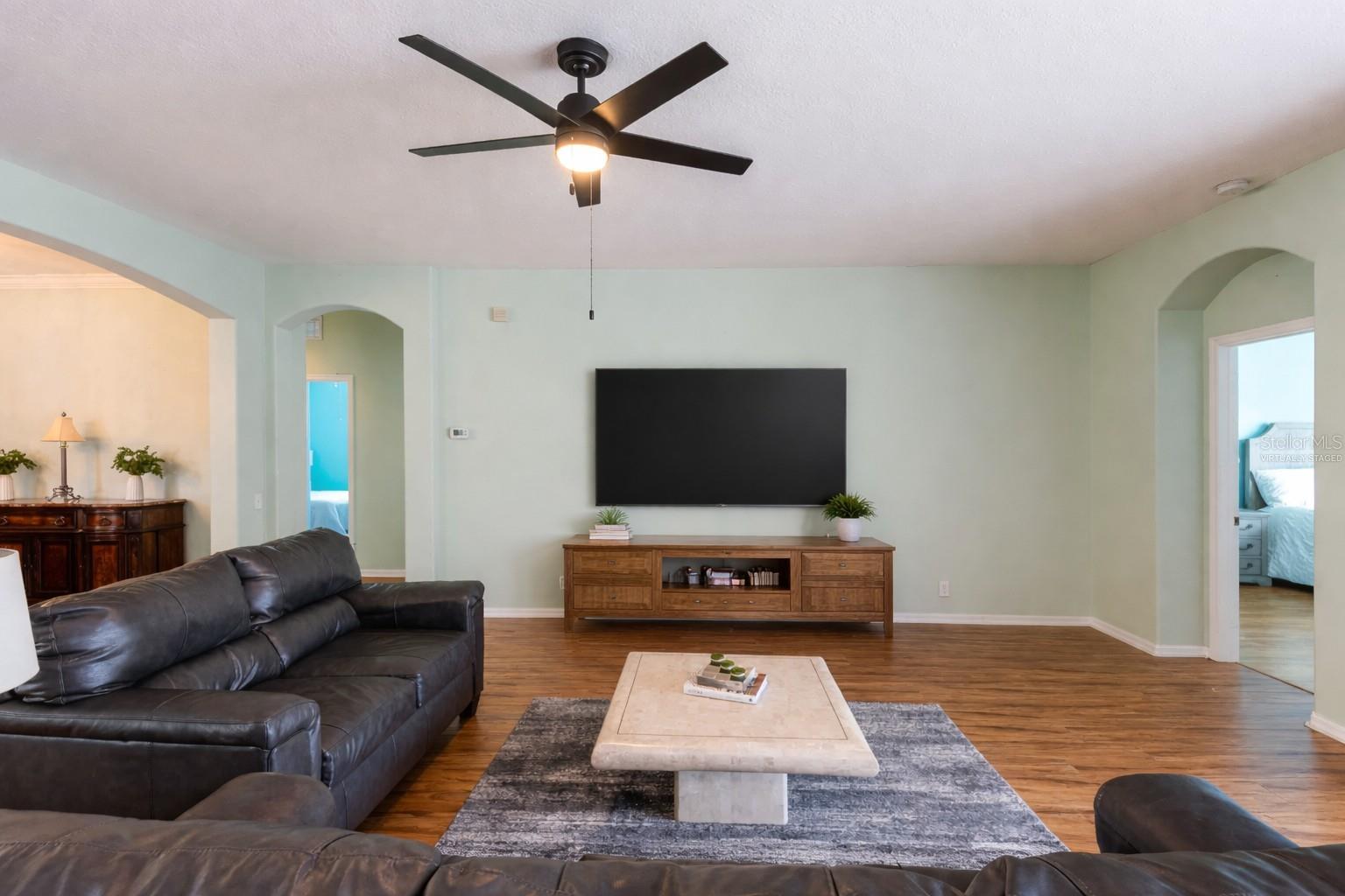 Great room with a virtually staged TV and stand.