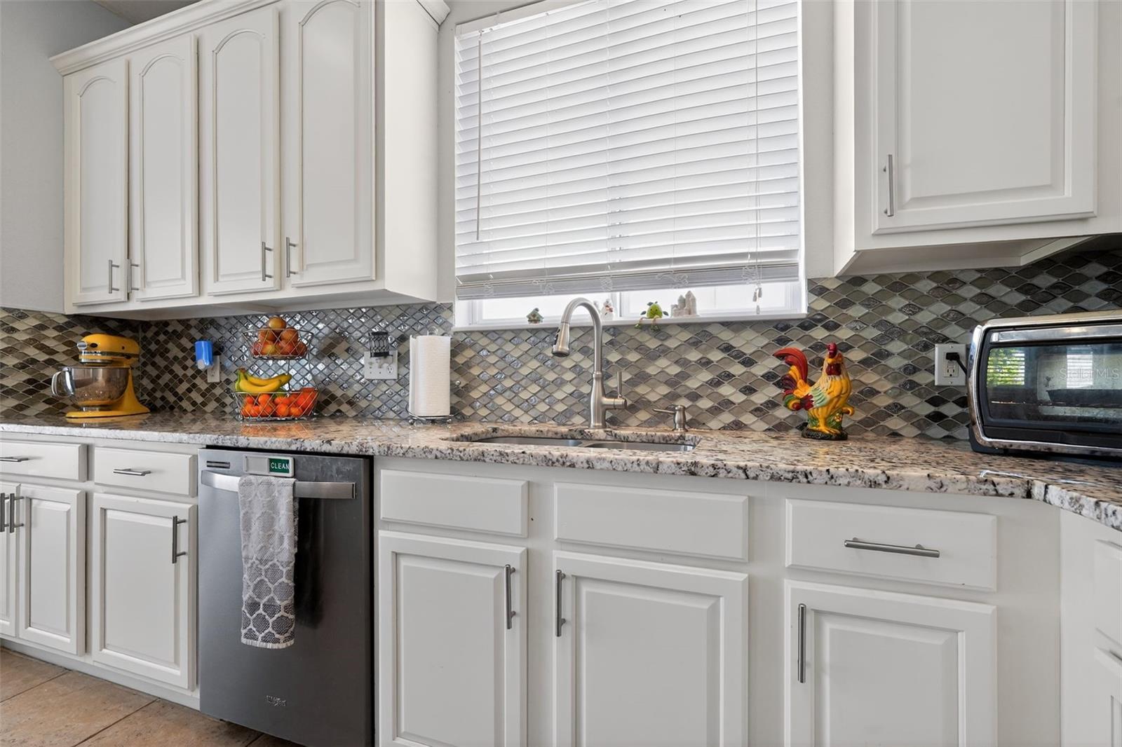 Kitchen w/Granite counters and glass tile backsplash