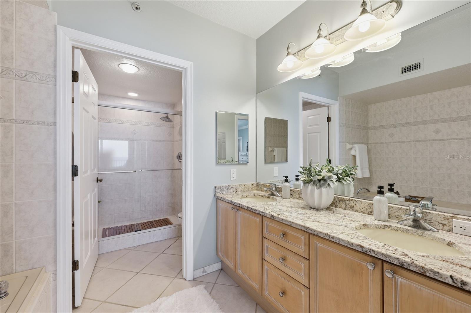 Primary bath has double sinks and oversized vanity with beautiful cabinetry