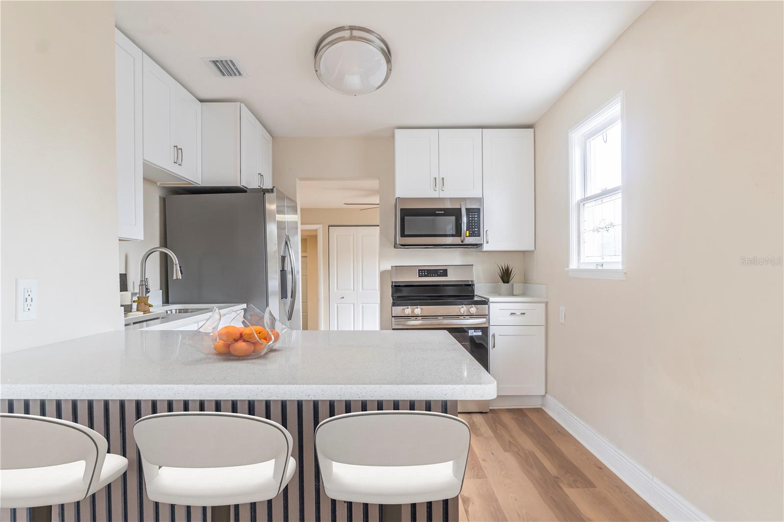 A peak into the kitchen, room for barstools at the quartz counter top