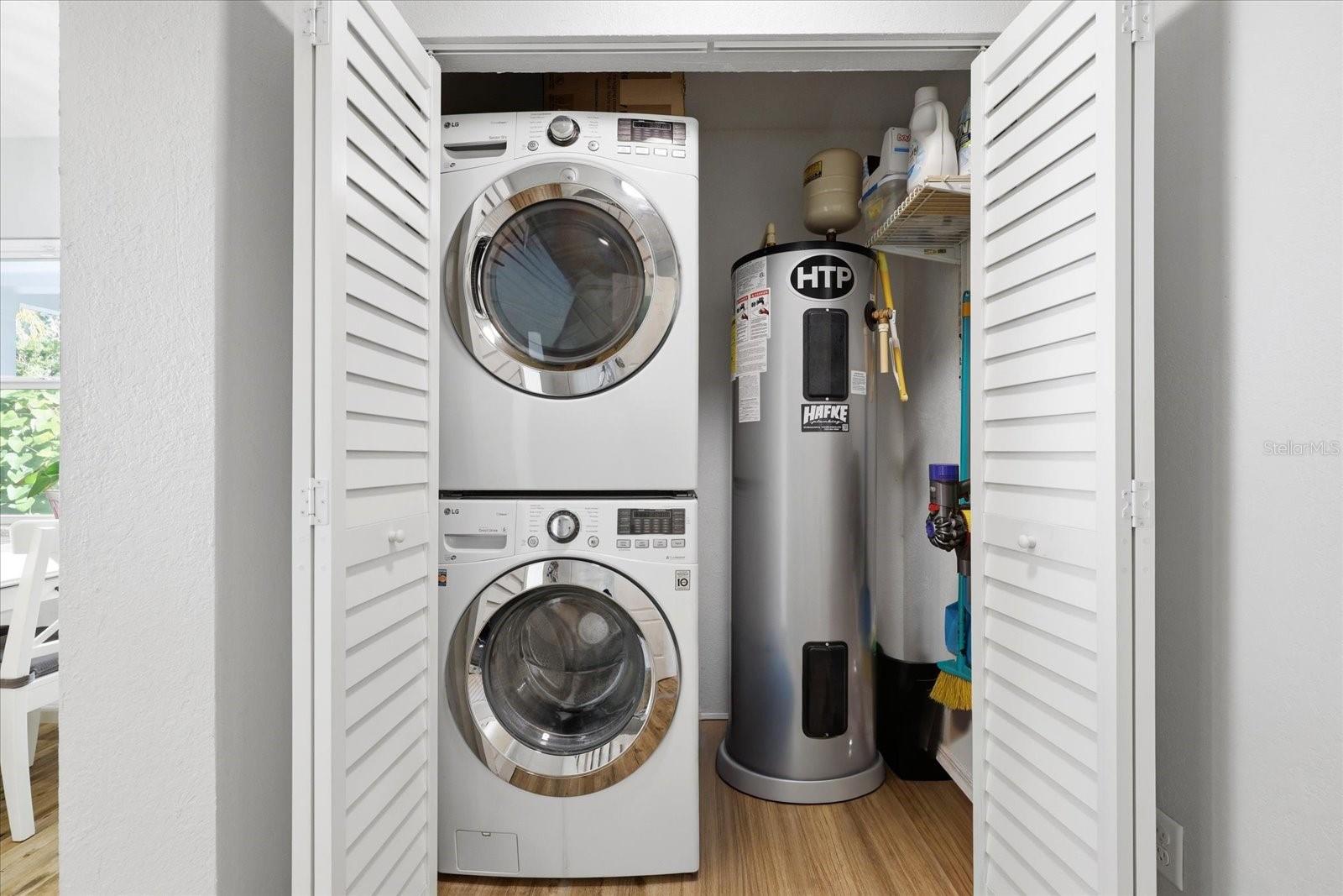 Interior laundry area with stacked washer and dryer