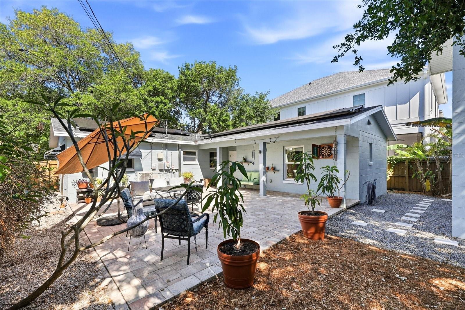 Private backyard with paver patio, seating area, and lush landscaping
