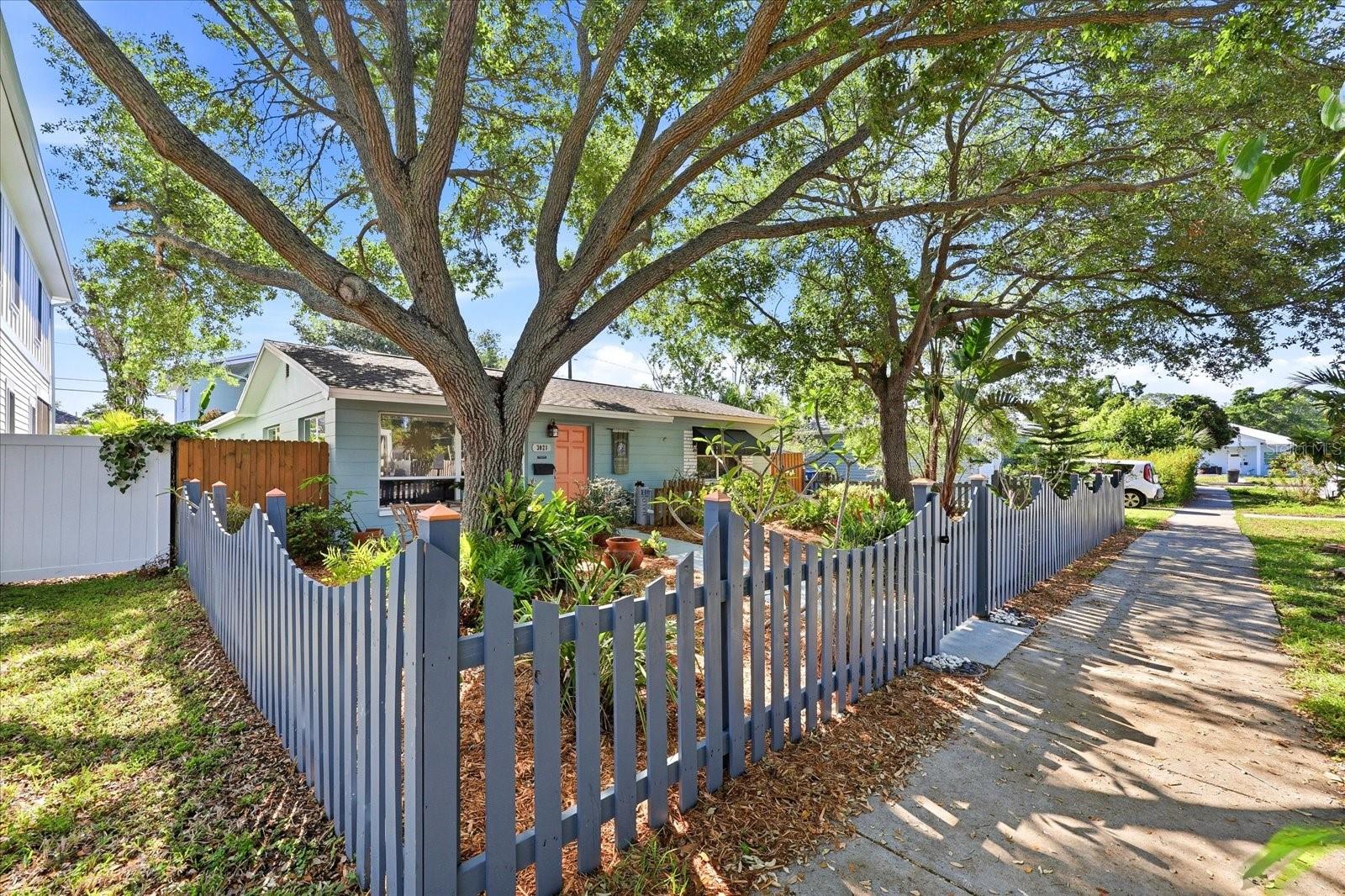 Corner view highlighting fenced yard and beautiful tree canopy