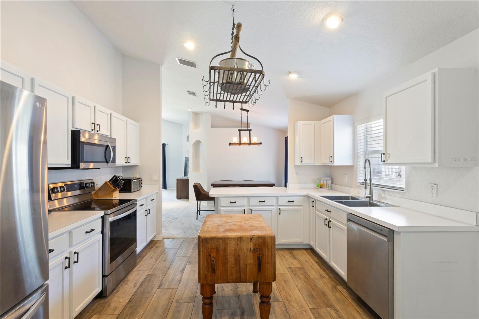 This kitchen is a cooks dream with the pot holder above the butcher block island!