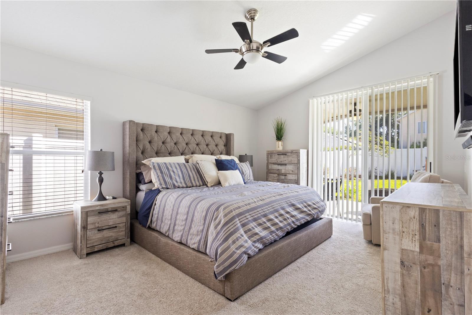 This comfortable primary bedroom has double sliding glass doors leading to the private back yard and covered patio.