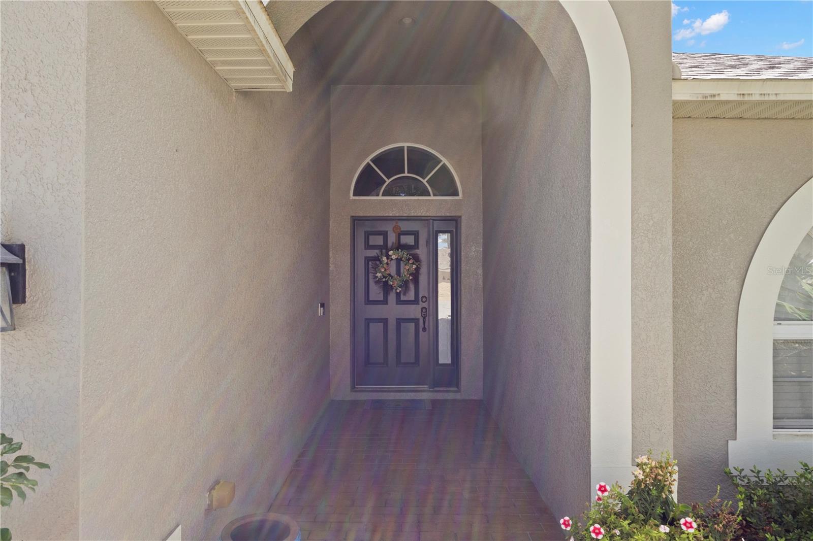 Inviting covered front entryway with arched architectural detail,