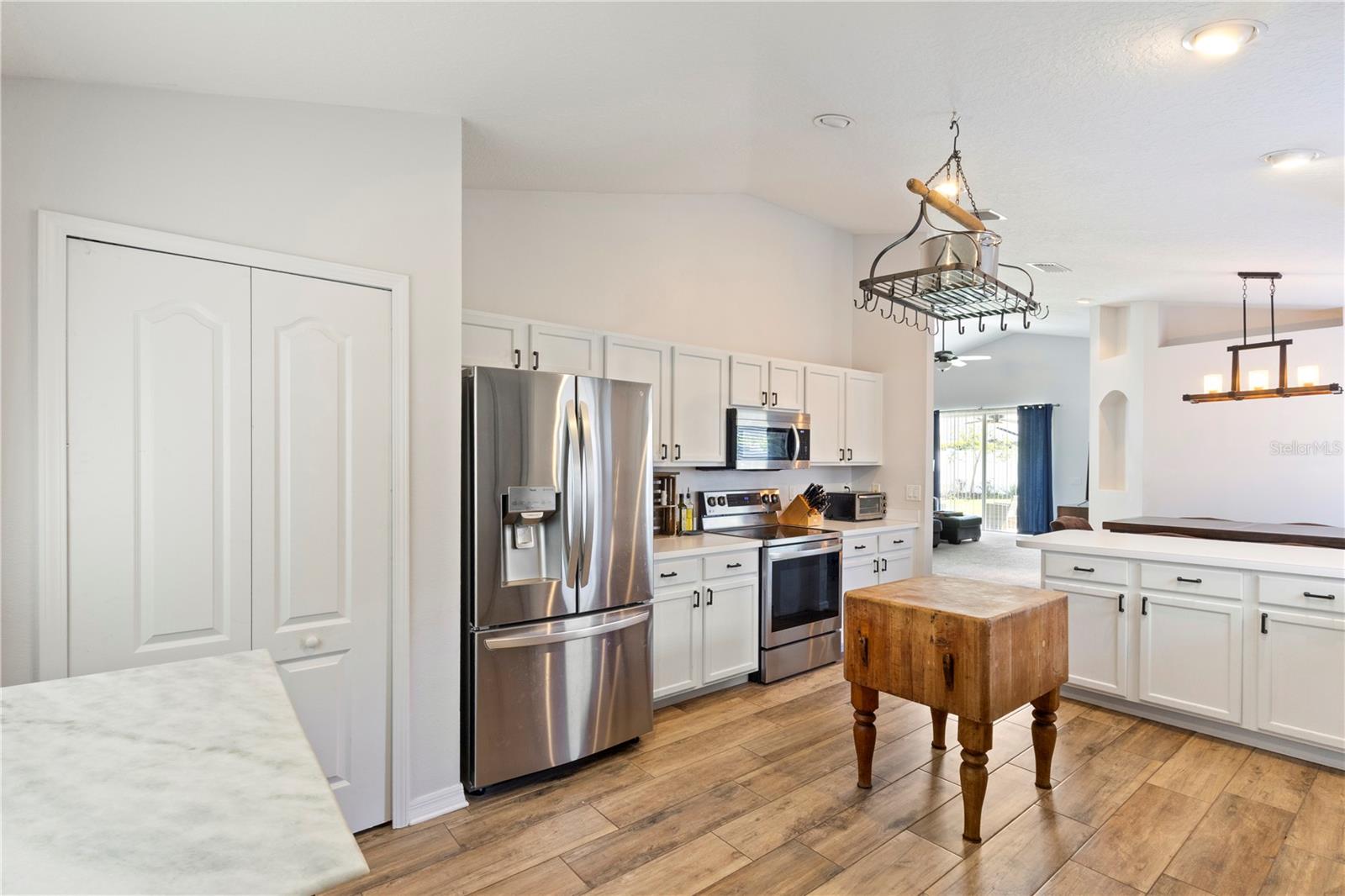 The kitchen features a stainless steel range, overhead microwave and French Door refrigerator with front water and ice dispenser.