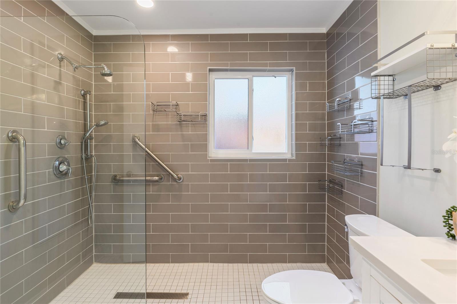 2nd bathroom with a large walkin shower with glass tile.