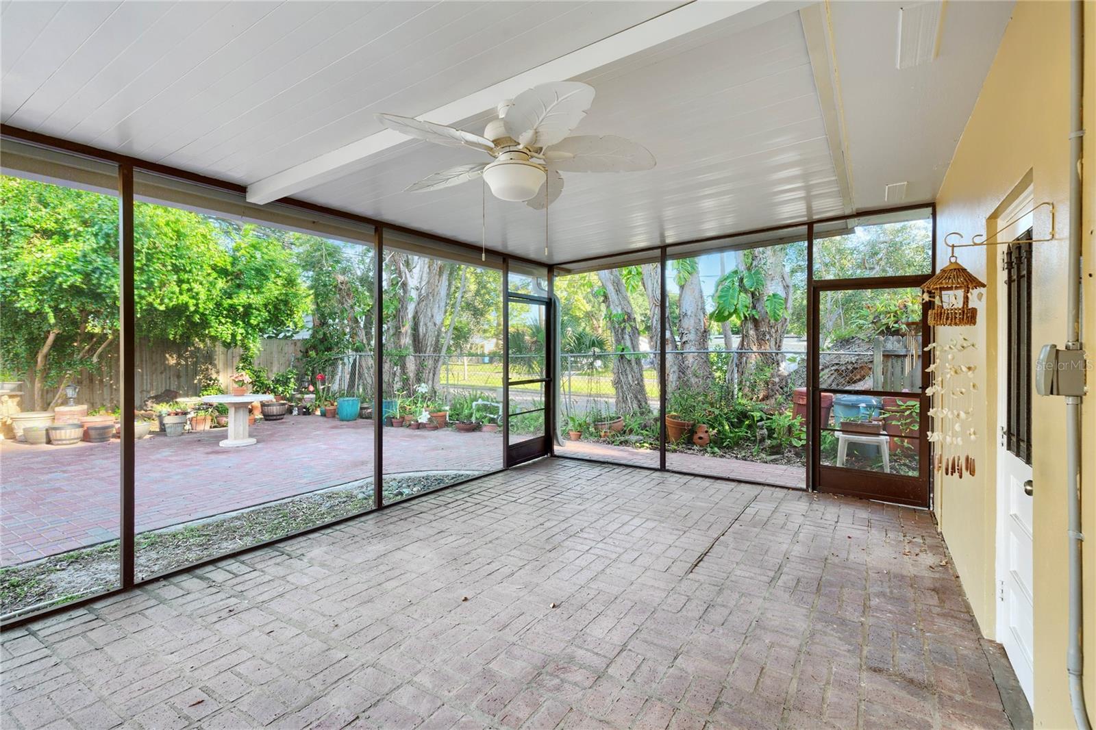 Covered patio space with a pet-proof, scratch proof screen and a real brick floor. access to the home lanai, outside patio and the garage.