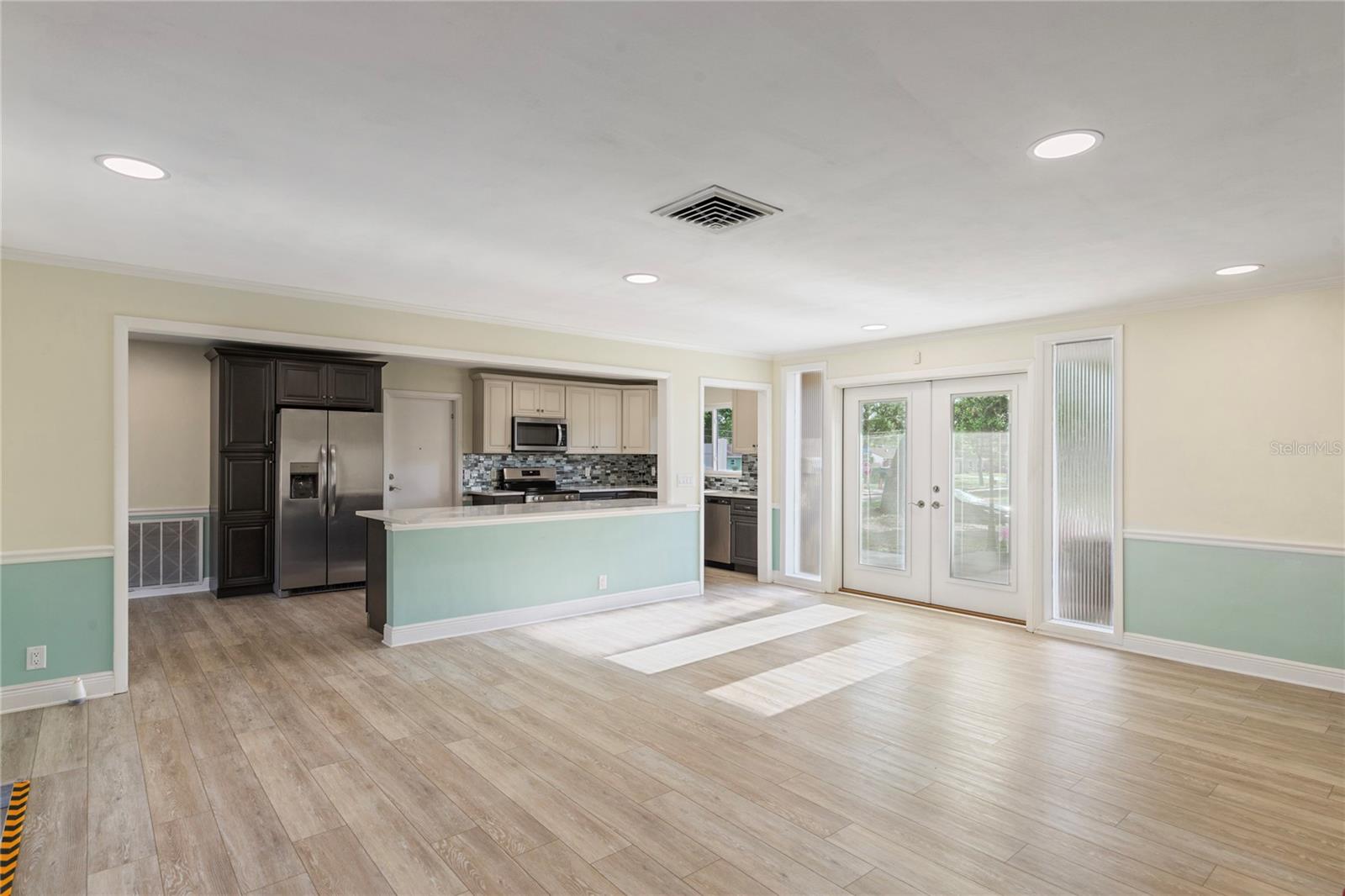 Light streams through the new front doors into a large open concept family room with all new flooring where friends and family gather.
