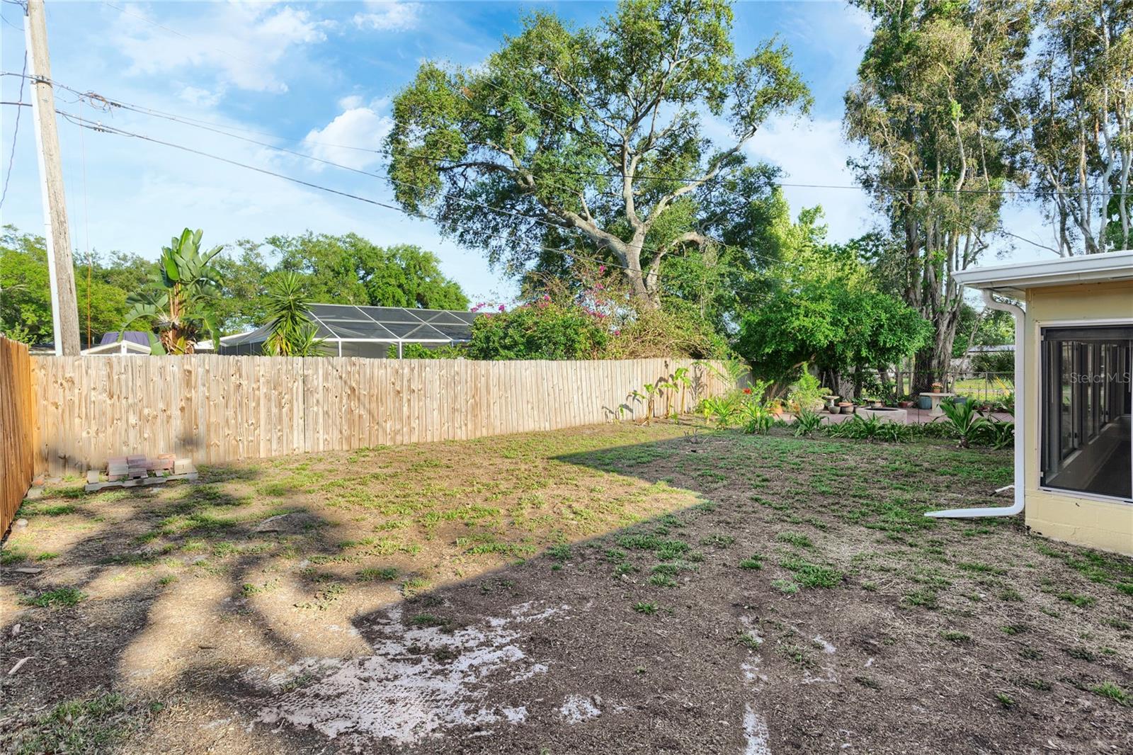 This shot is from the side yard looking into the back area with plenty of room for a pool or and ADU - and the new brick paved patio beyond.