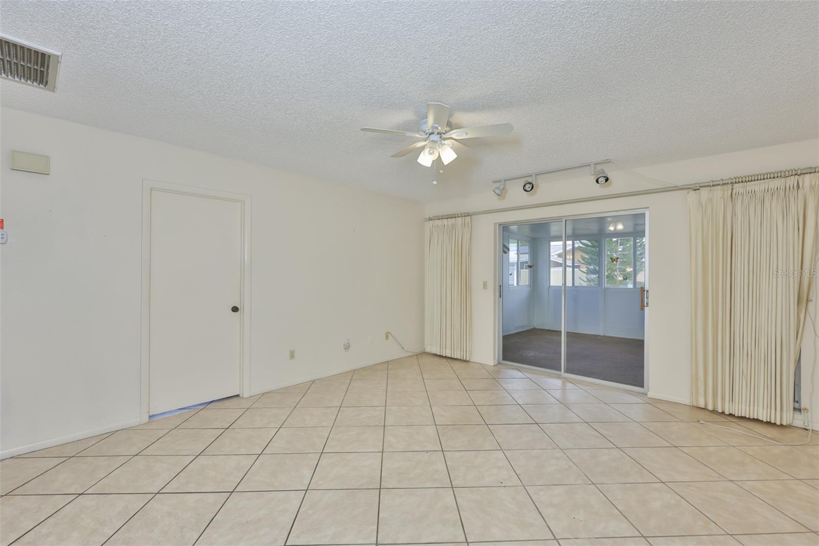 Family room. Door to Primary Bedroom and sliders to Sunroom