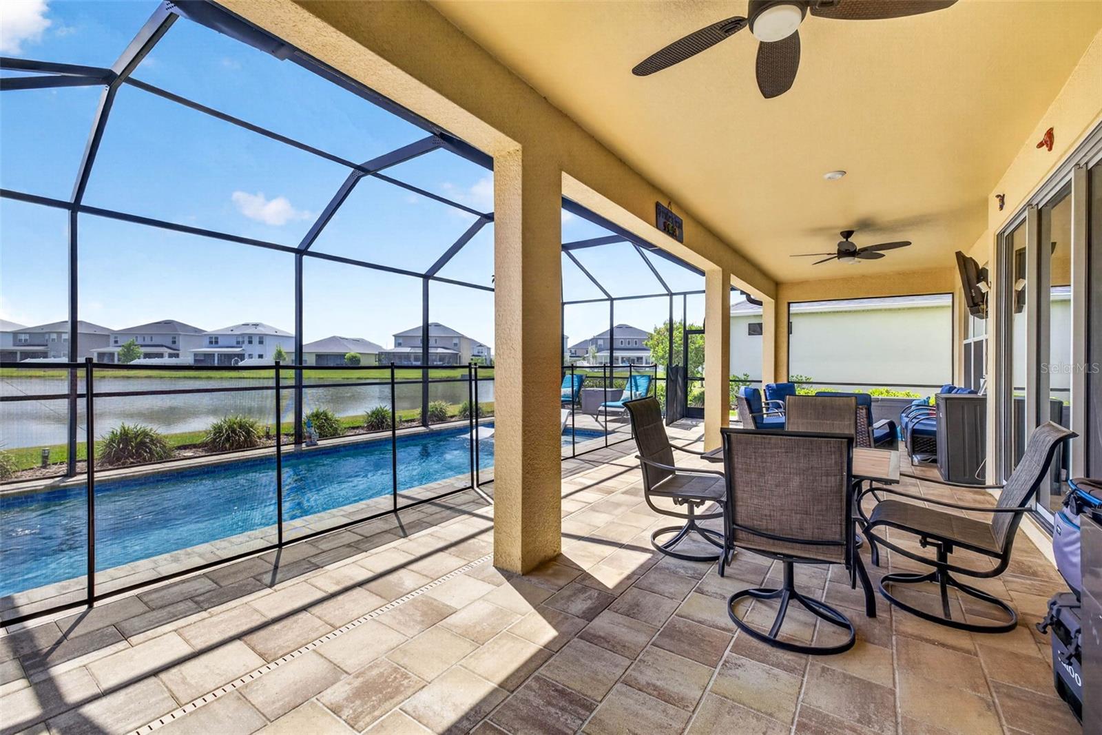 Paver deck, enclosed pool area, with dining and seating area.