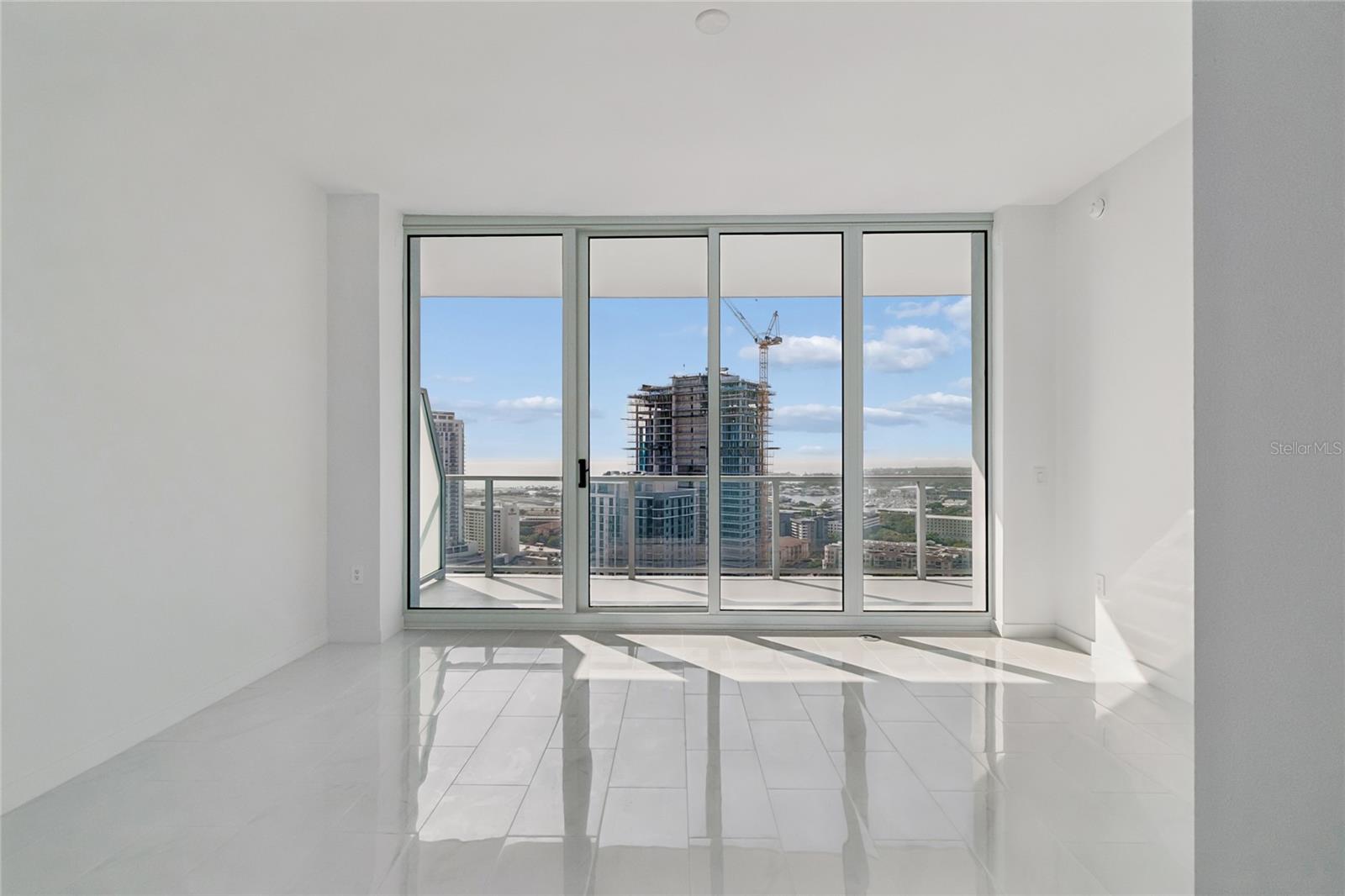 Full wall of glass in primary bedroom with direct access to balcony
