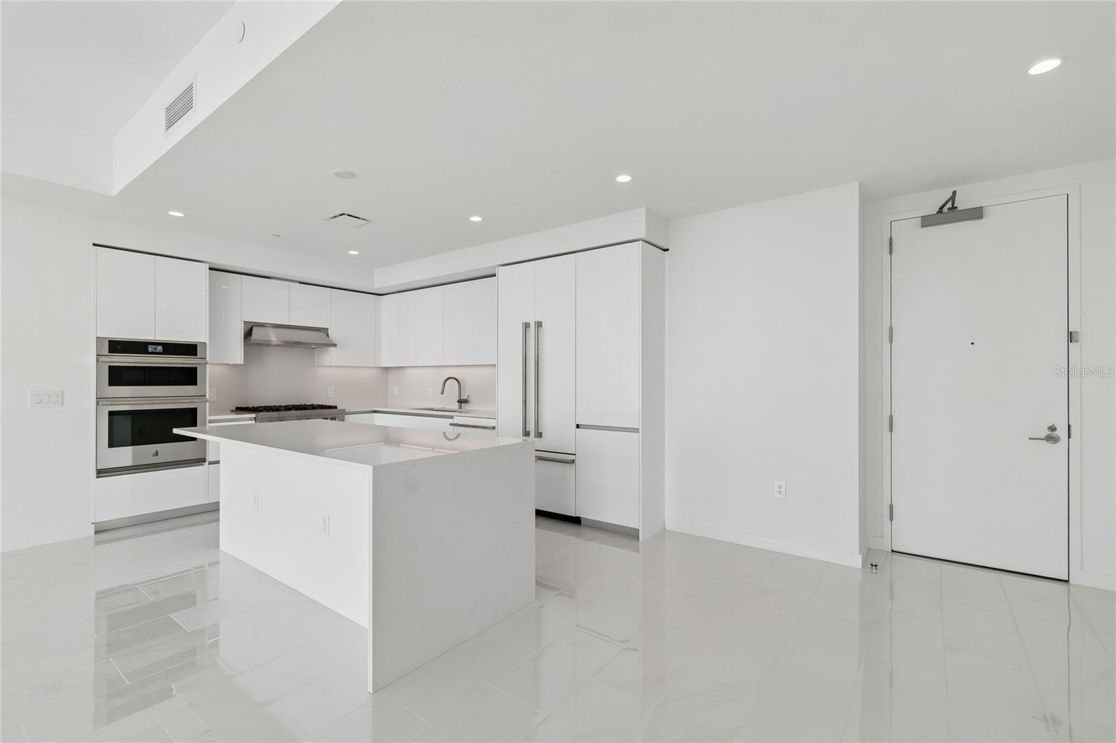Custom upgraded high gloss cabinetry with matching refrigerator door panels