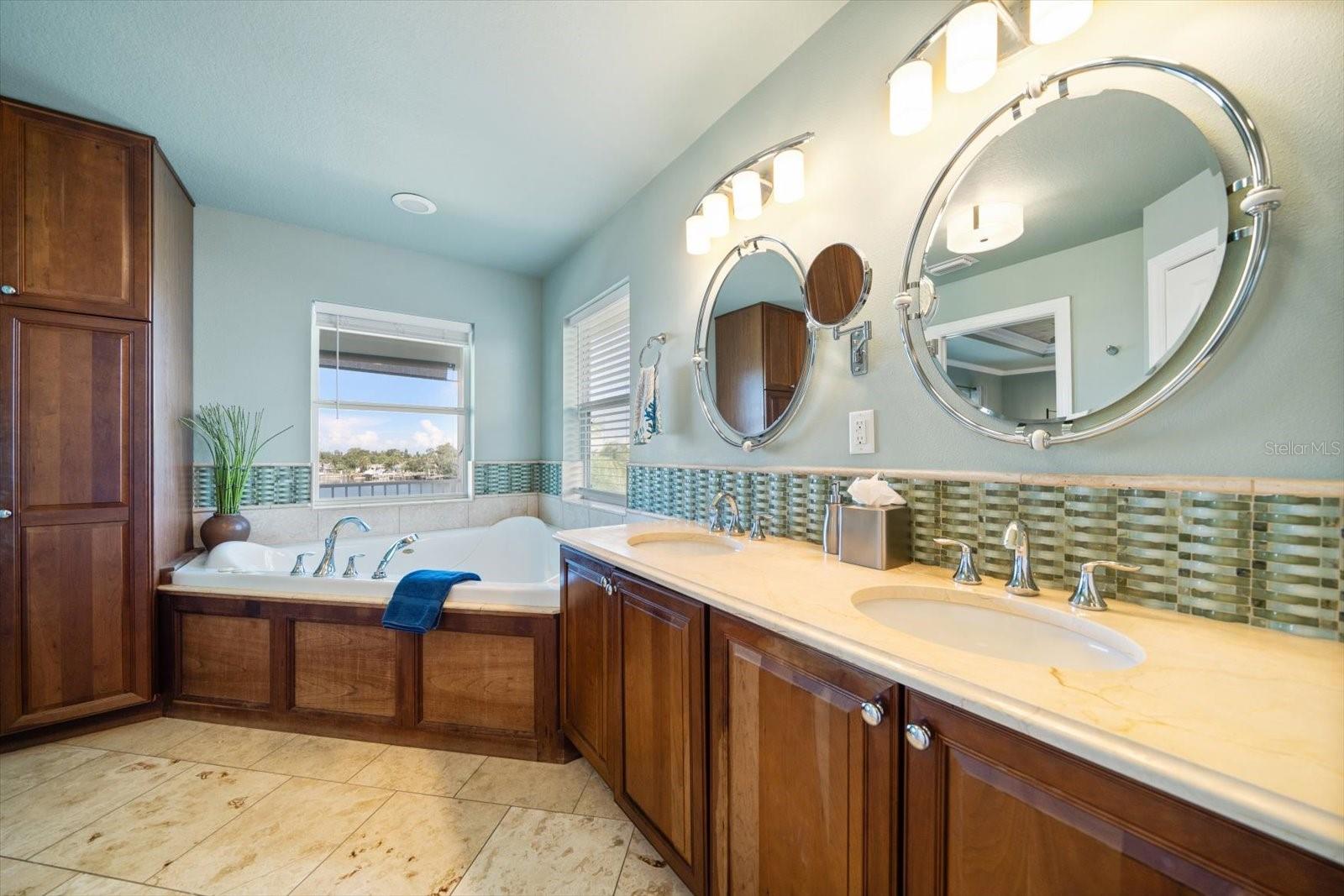 The primary bathroom features dual sinks, walk in shower, soaking tub, and plenty of storage.