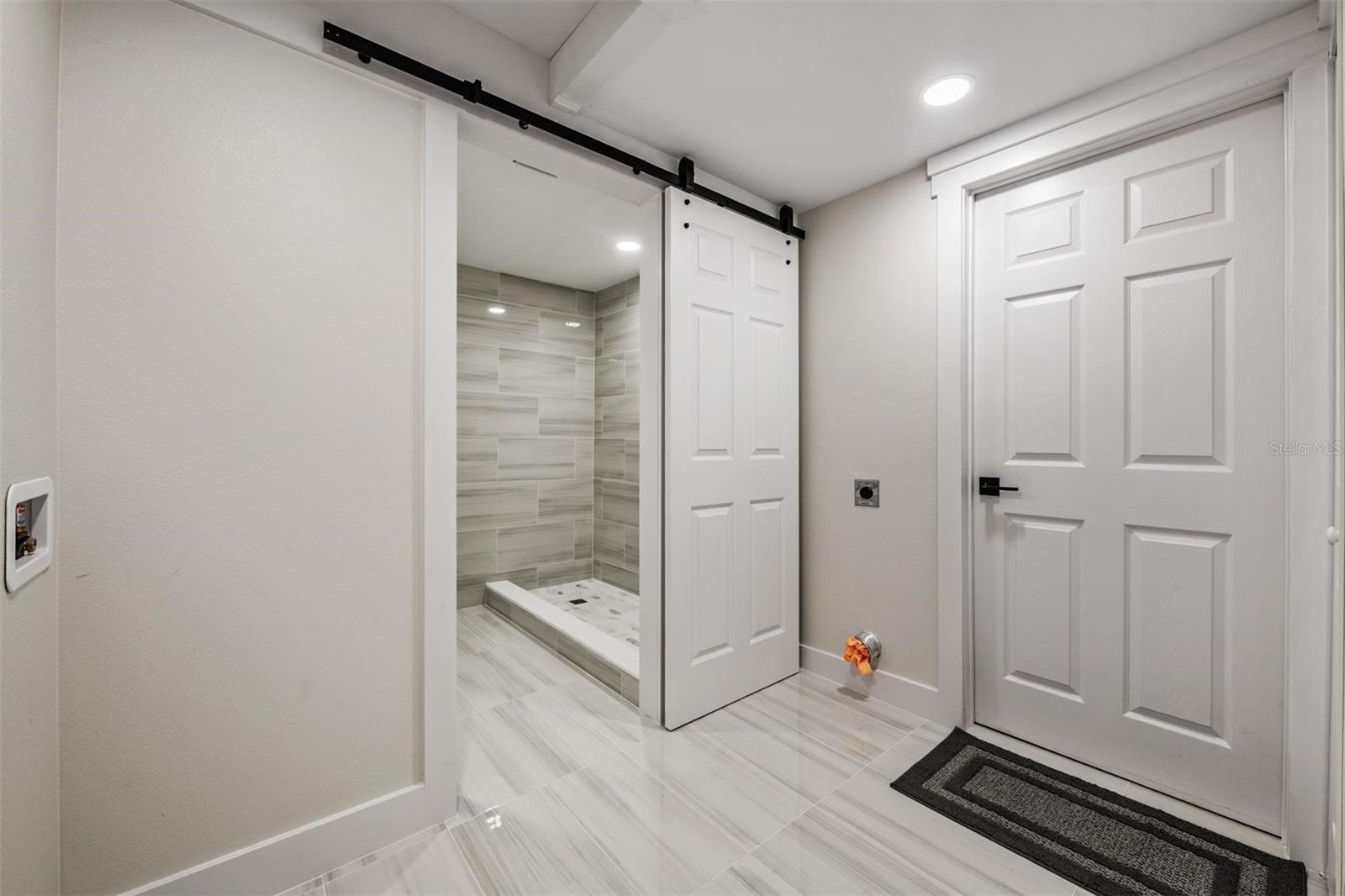 Laundry room with full shower bath and door into the garage.