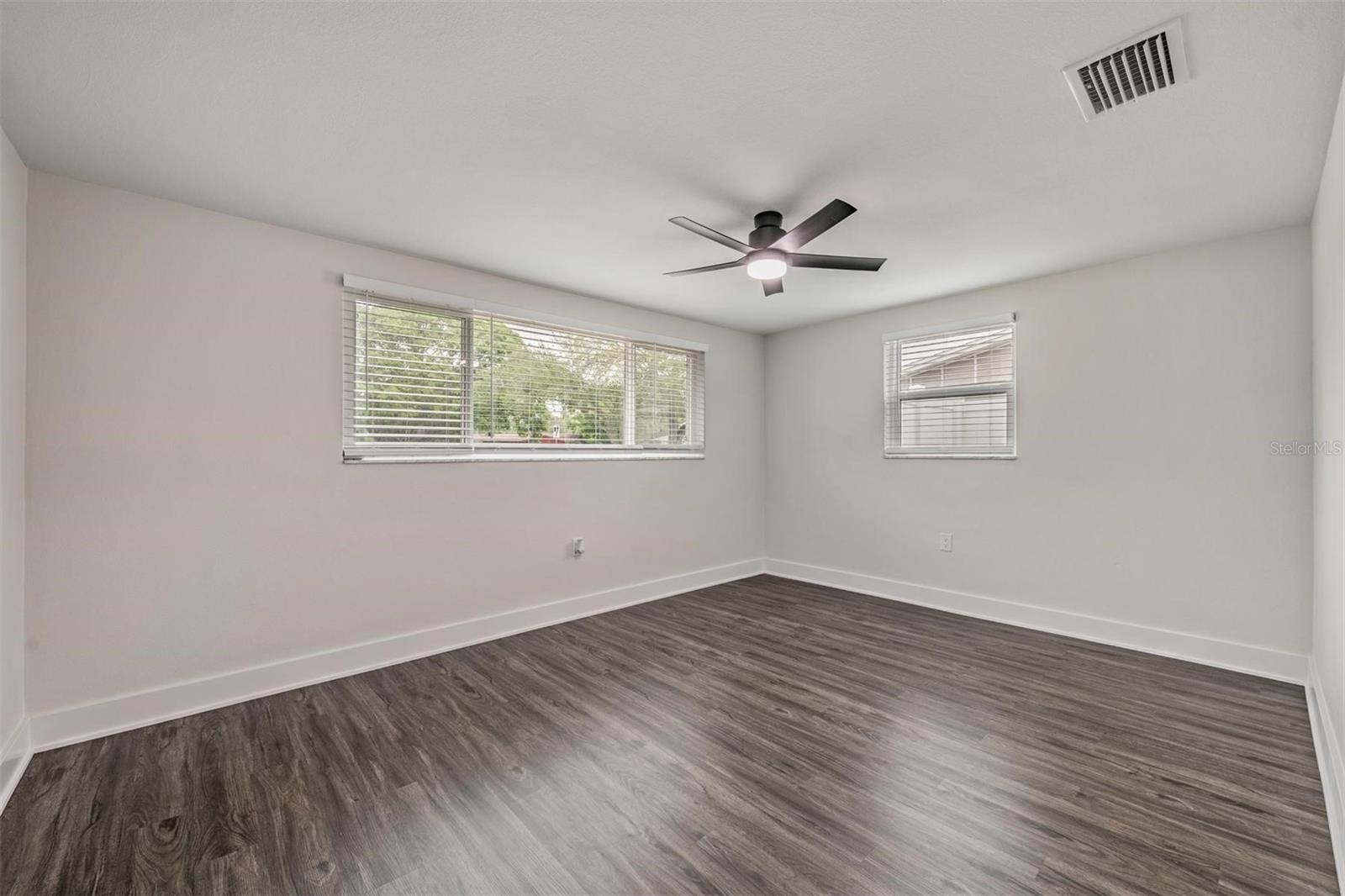 Bedroom #2 with new door, new large closet doors. New windows, floors, fan/light, HVAC vent and blinds.