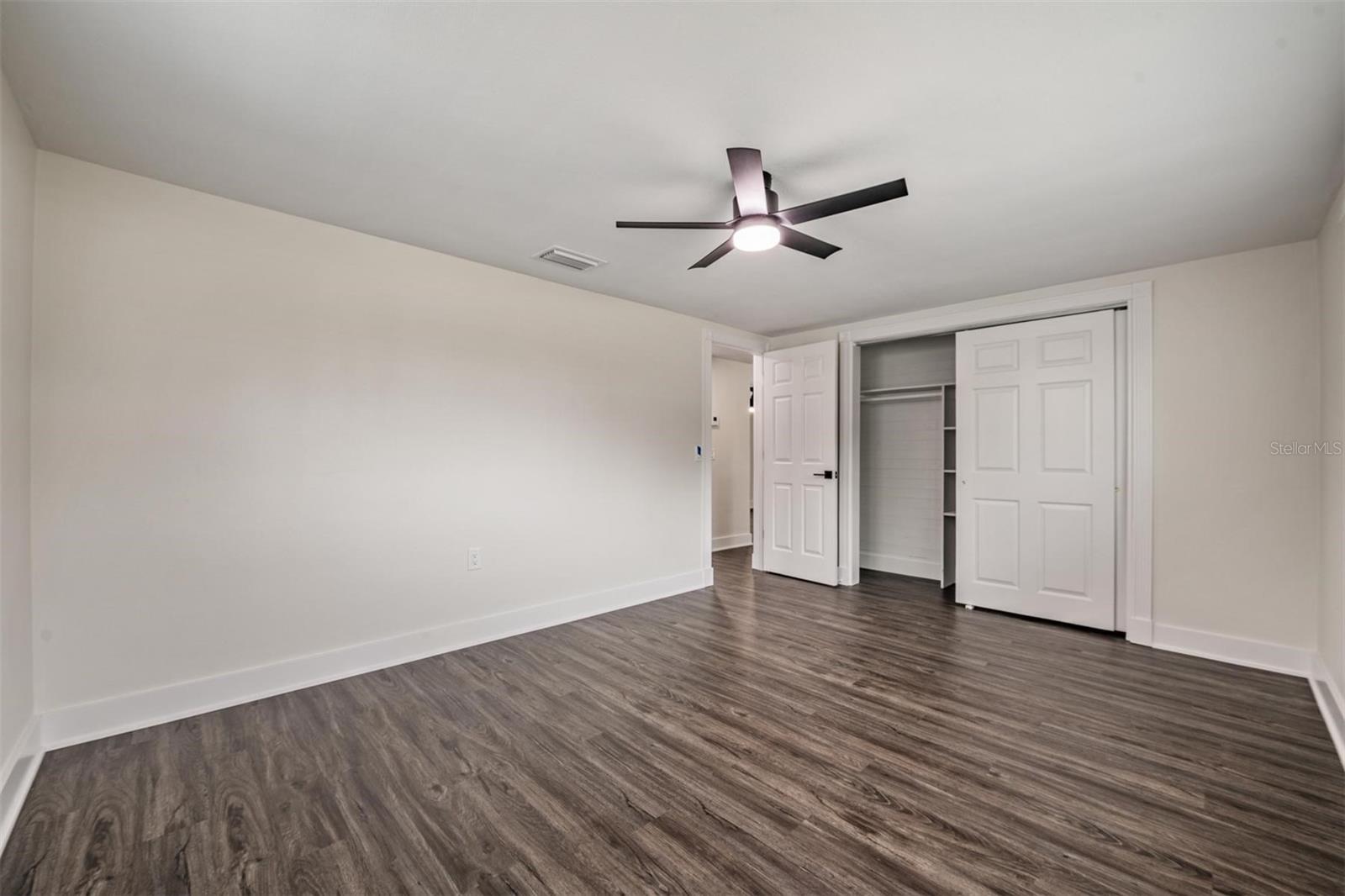 Bedroom #3 with new door,  large new closet doors. New windows, floors, fan/light, HVAC vent and blinds.