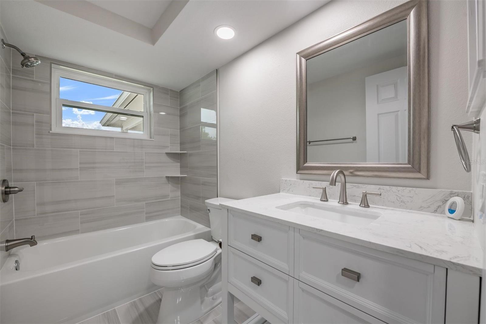 Community Bathroom next to 2 bedrooms. All new vanity, toilet, mirror, hardware, window, tile and can lights.