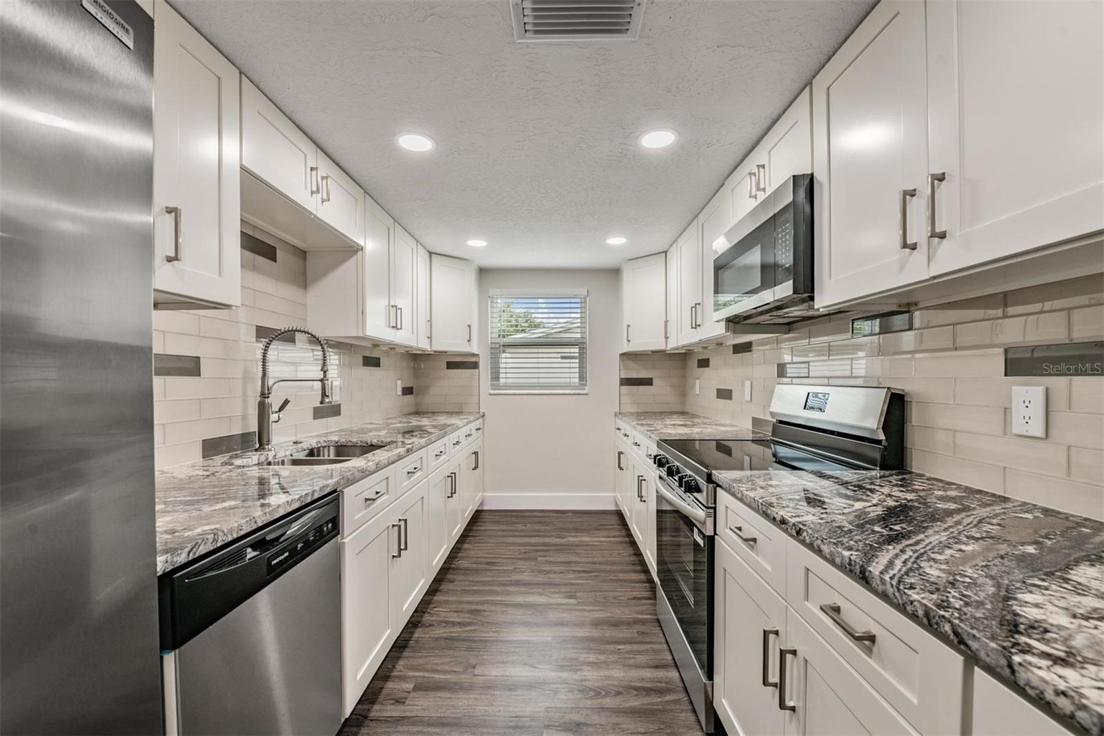 Luxurious kitchen.  All new appliances, granite countertops, shaker cabinets, hardware, flooring, can lights.