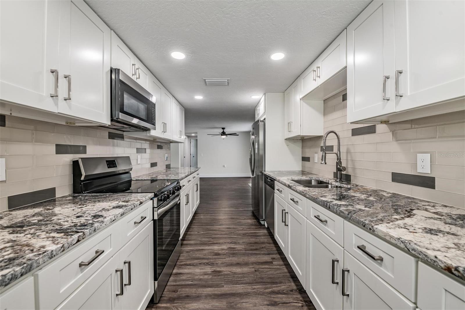 Luxurious kitchen.  All new appliances, granite countertops, shaker cabinets, hardware, flooring, can lights.