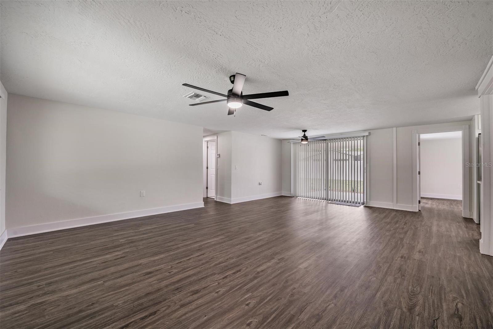 Living Room and Dining area, Door way to LEFT are 2 beds and a bath.  Doorway straight ahead is Primary Bedroom with sliders to the patio.