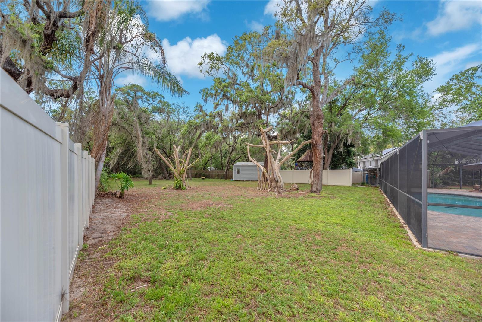 The fully fenced yard is perfect for pets to roam freely and mature trees, including two stunning banyan trees, enhance the serene setting.
