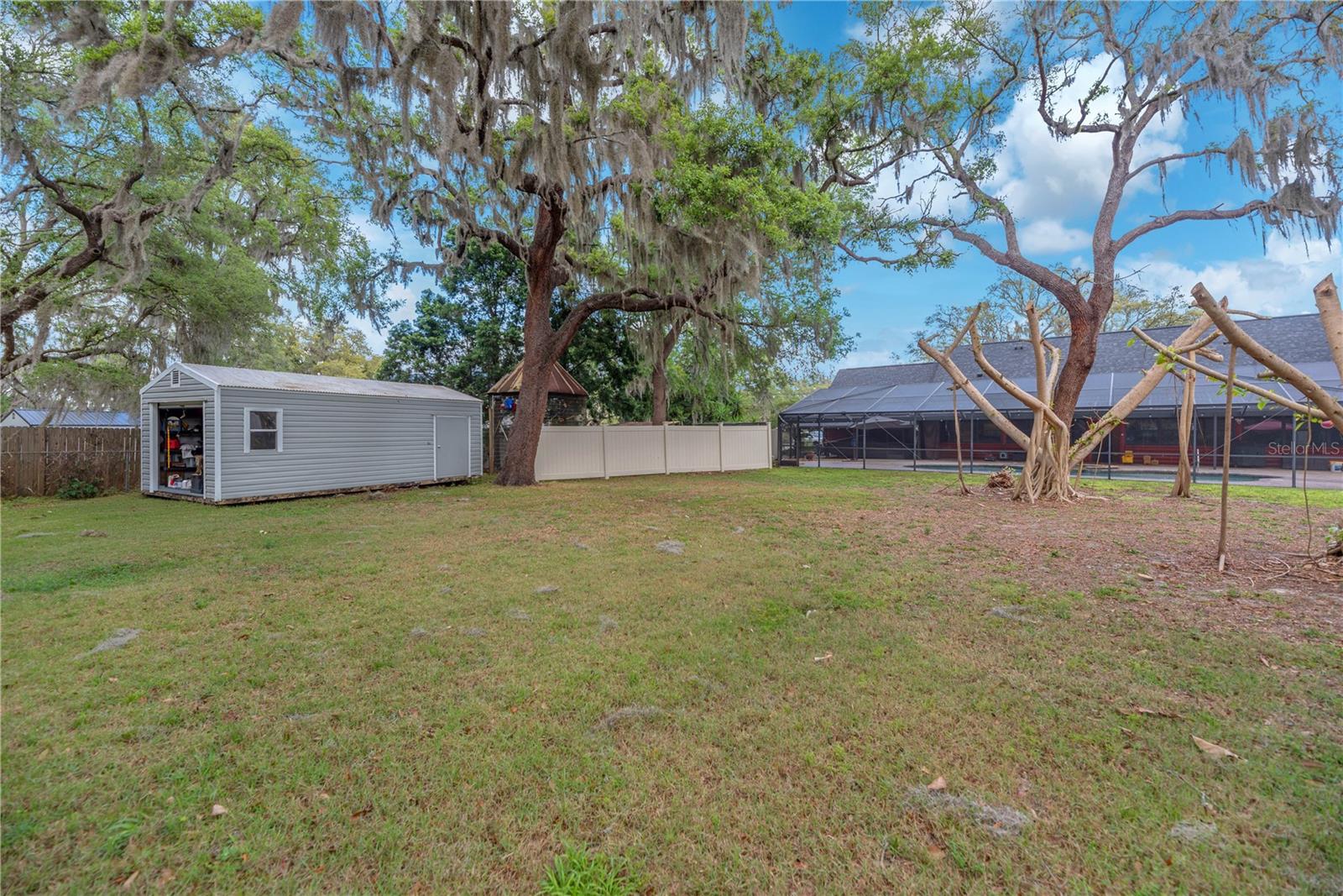 There is a 12x23 shed with roll up door for additional storage and a partial privacy fence separates the pet kennels from the rest of the yard.