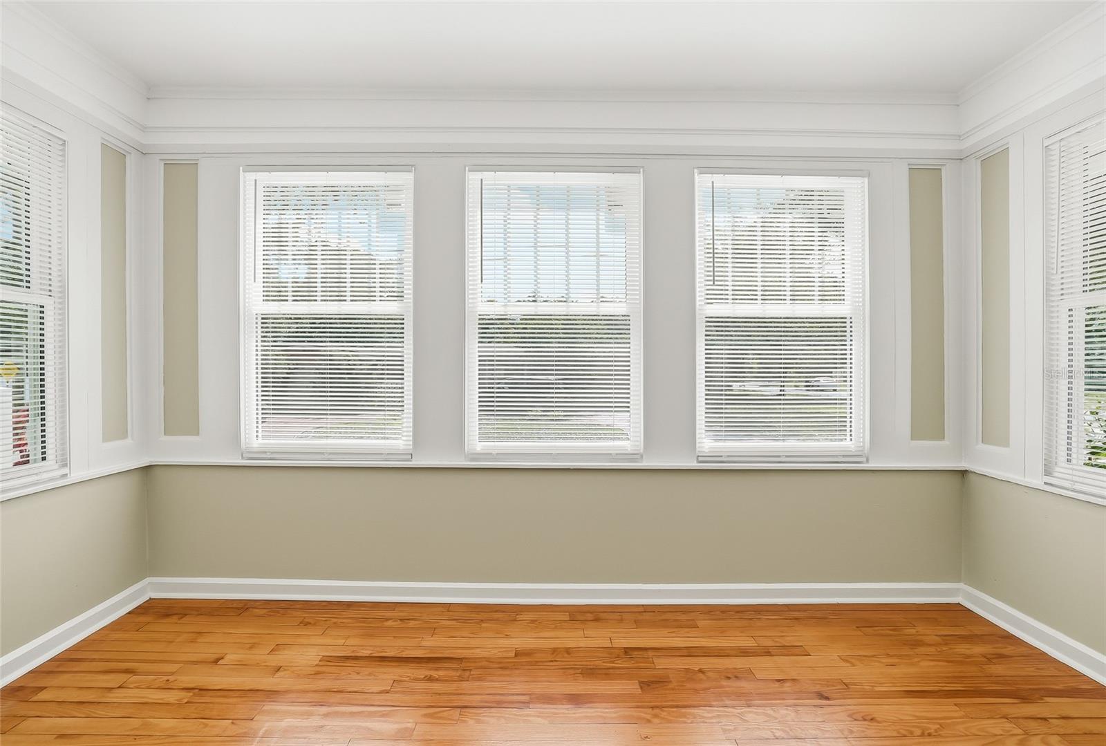 Bright sunroom offers flexible space for a den, office, reading room, or creative retreat.