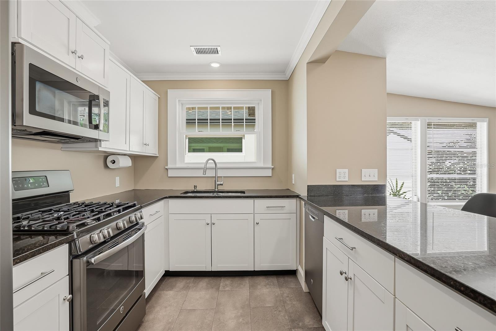 Updated kitchen with stainless steel appliances and stone countertops.