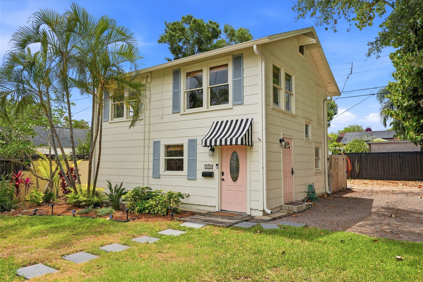 Front of home and view of door to access 2nd floor staircase, parking spot, and alley access.