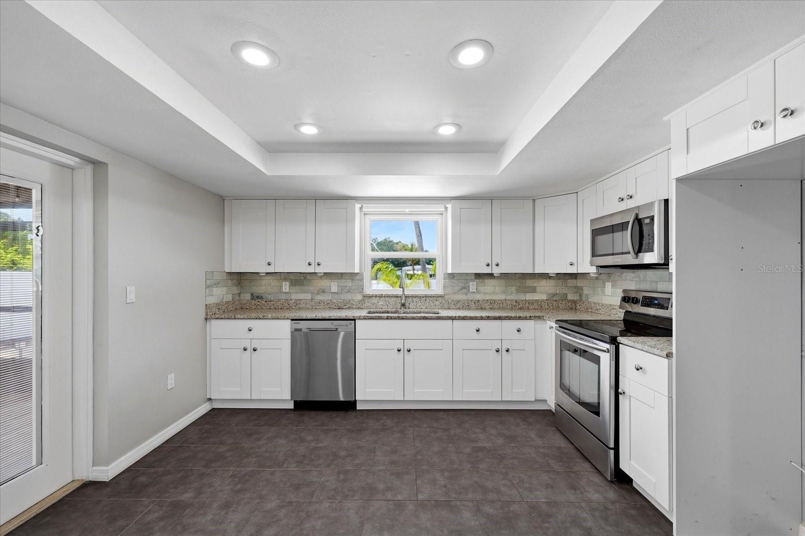 Updated Kitchen with Large Layout that leads directly to the Enclosed Porch/Pool