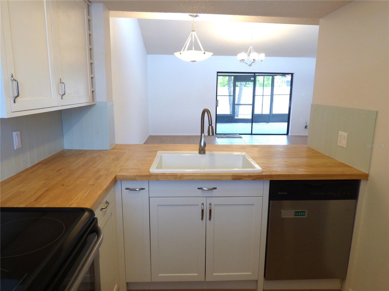 The updated kitchen features new butcher block counters and an elegant farm sink