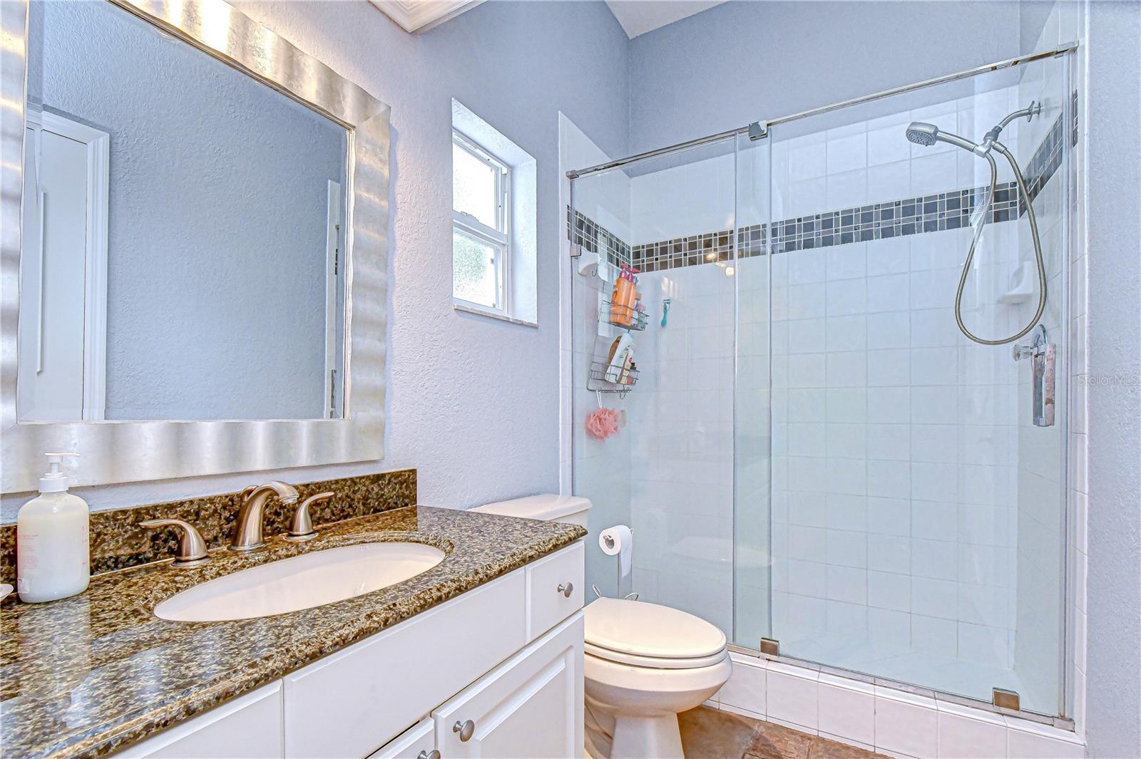 Updated guest bathroom with granite countertops and custom cabinetry