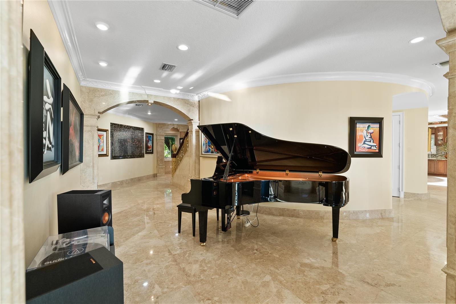 A refined art corridor where the grand piano becomes both centerpiece and statement, enhanced by a custom backlit stone installation that elevates the space with a gallery-style ambiance.