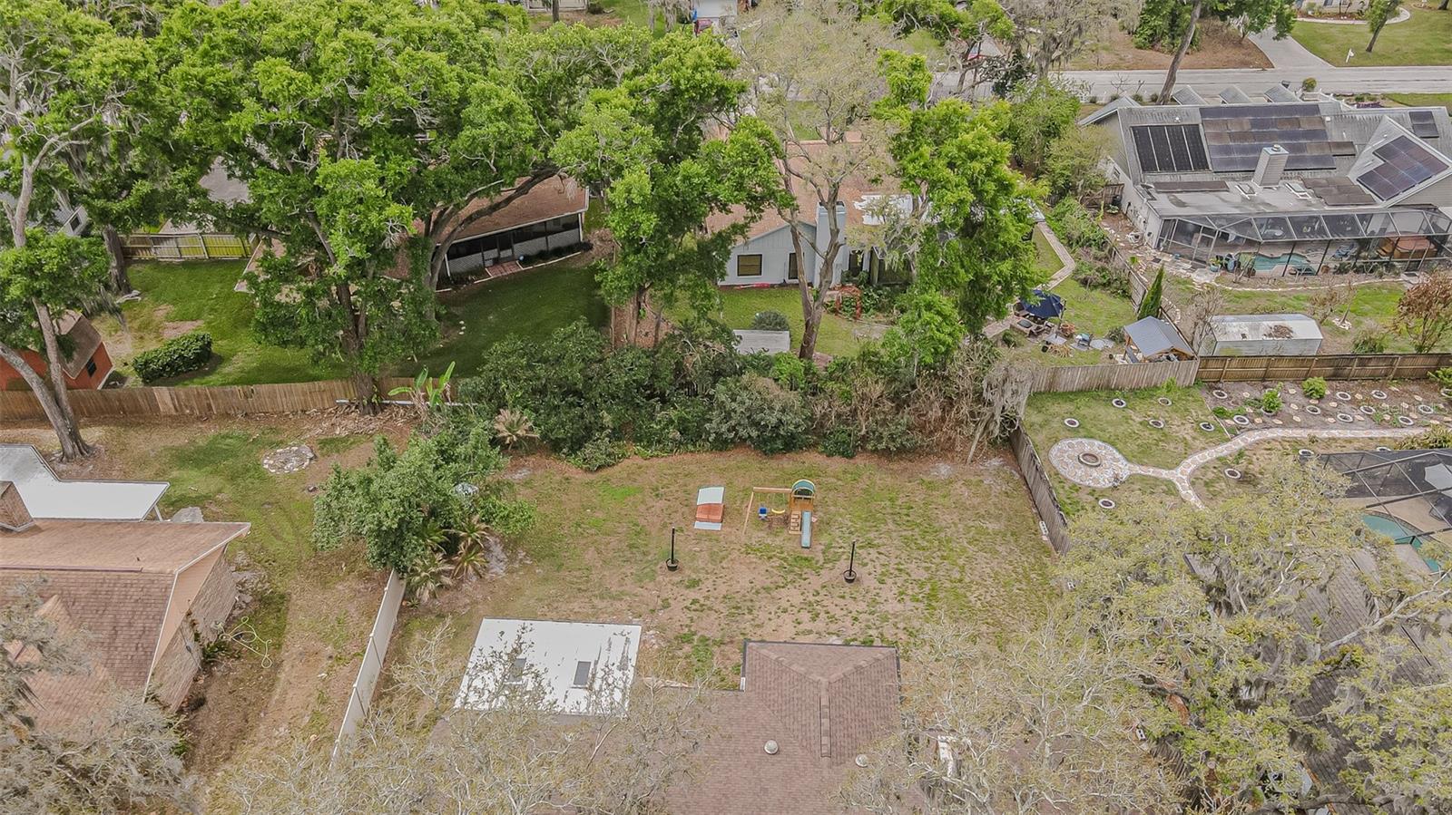 Private backyard with mature landscaping along the fence line.