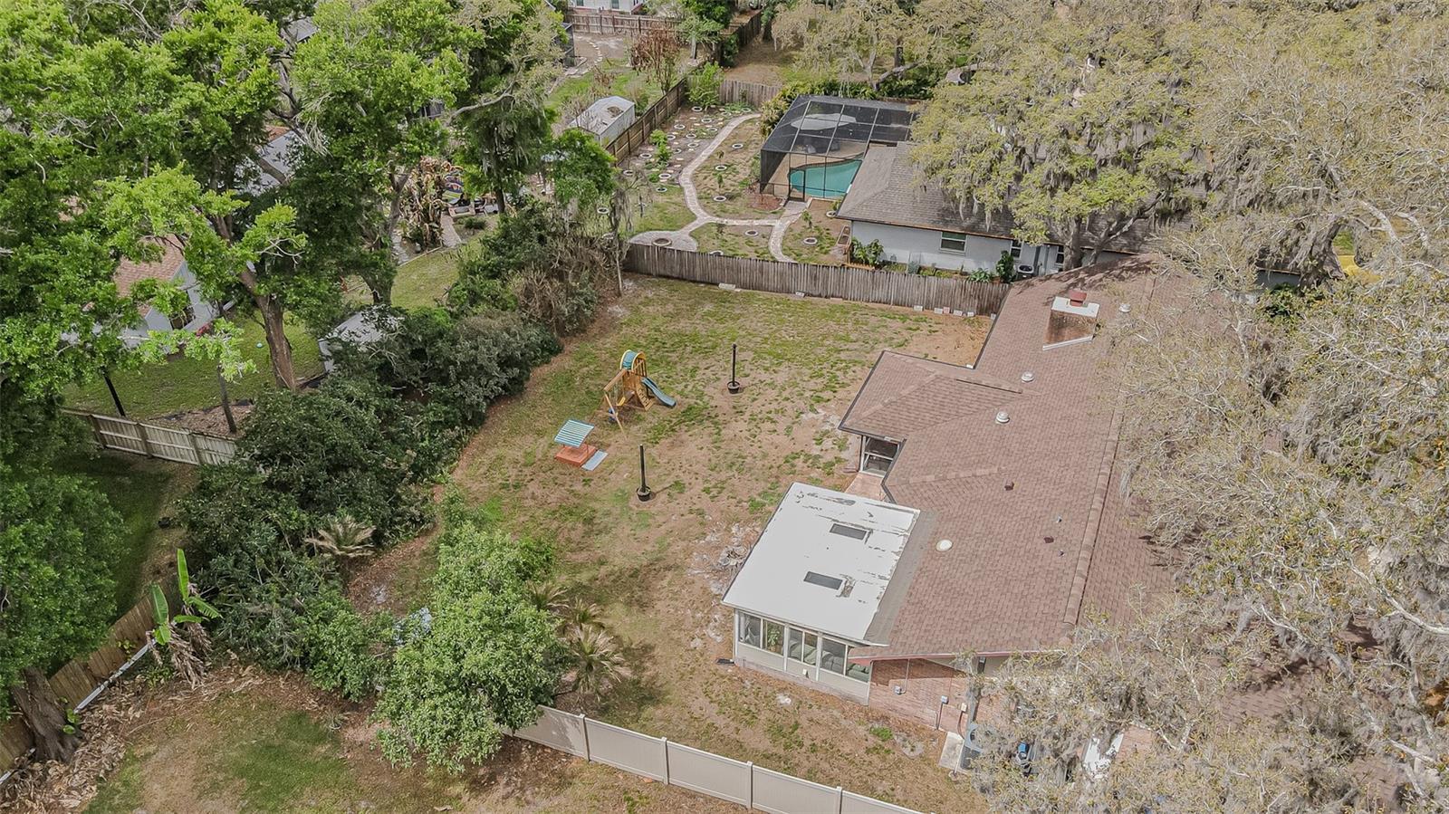 Private backyard with mature landscaping along the fence line.