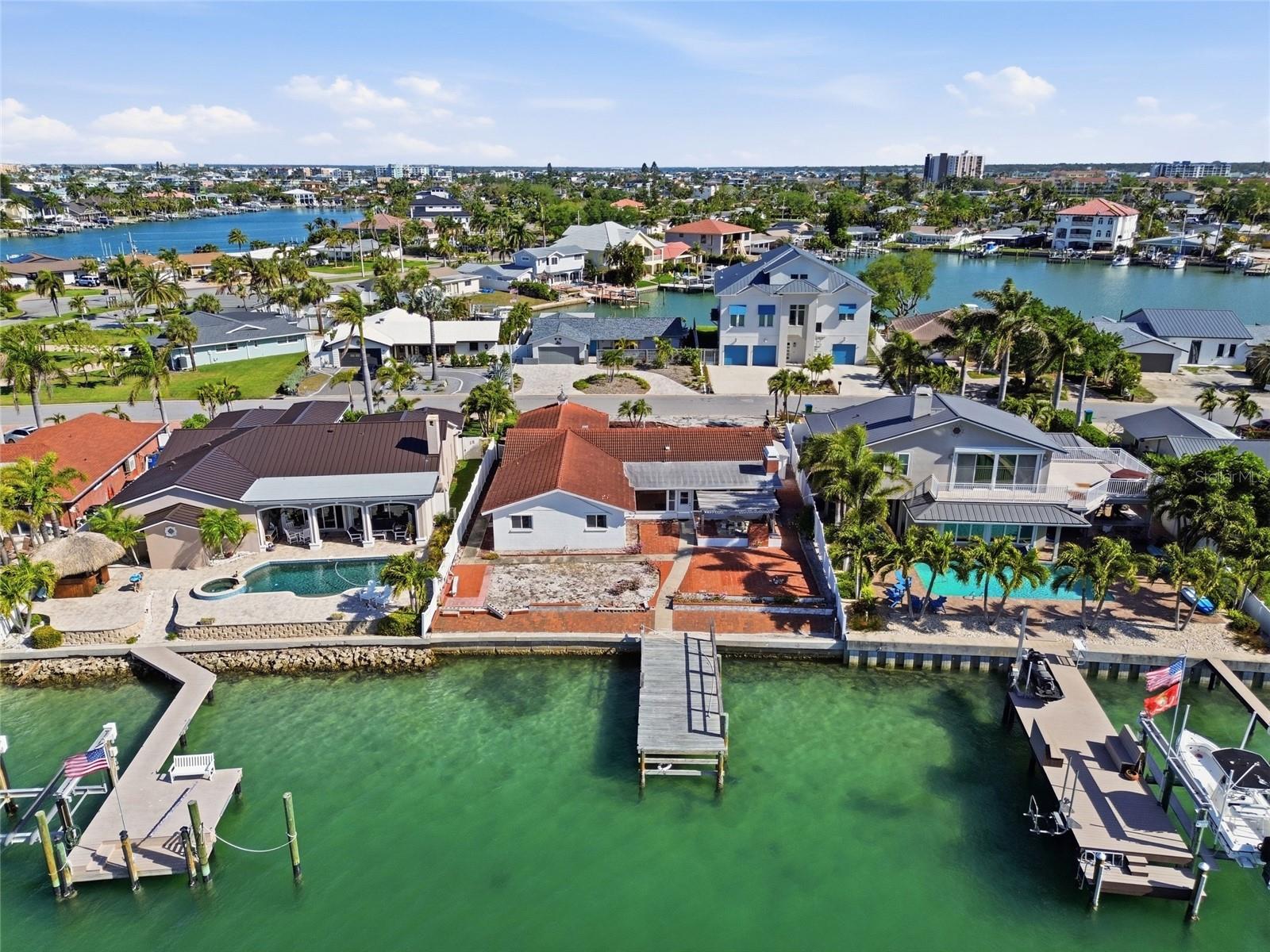 Drone photo of the back of 4 Bellevue looking north at the seawall, dock and rear of the home.