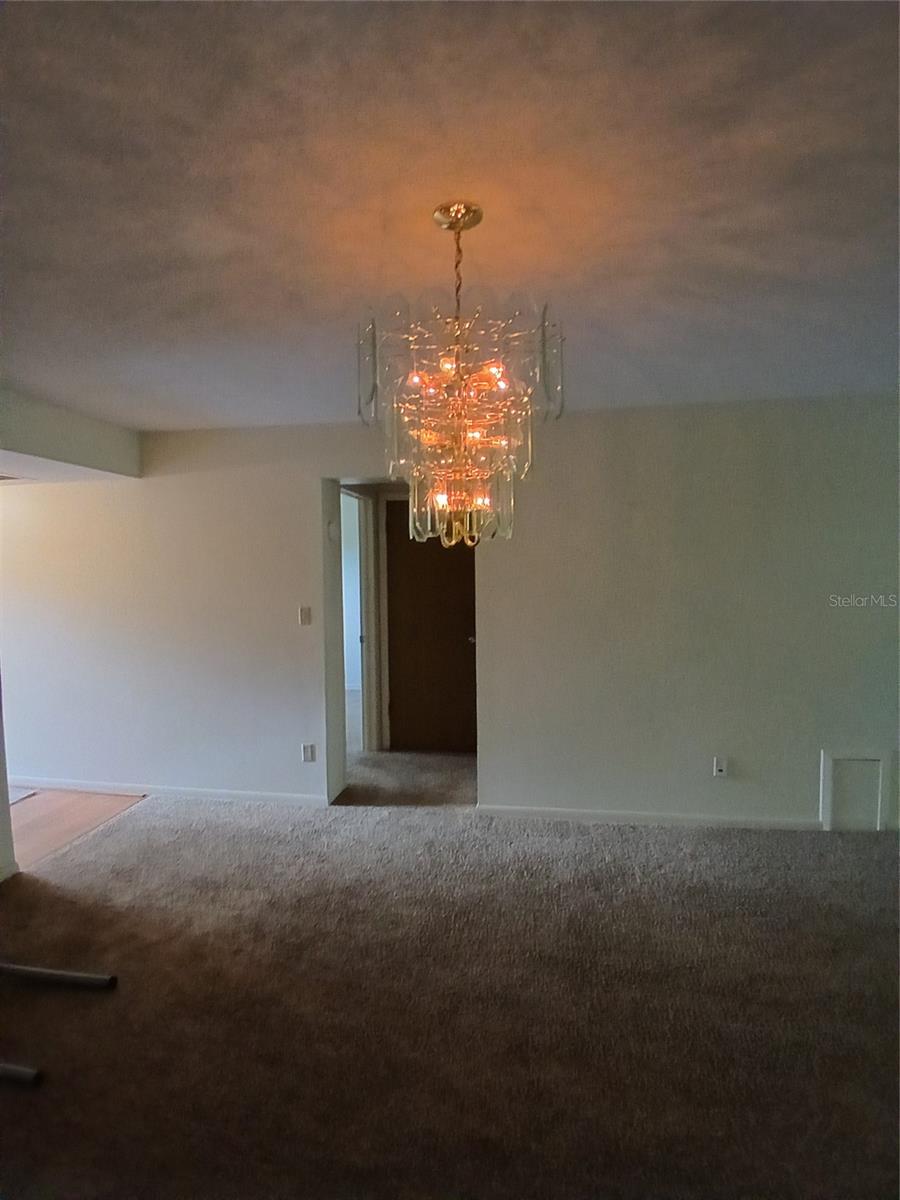 Dining area with over the table chandelier right outside of the kitchen.