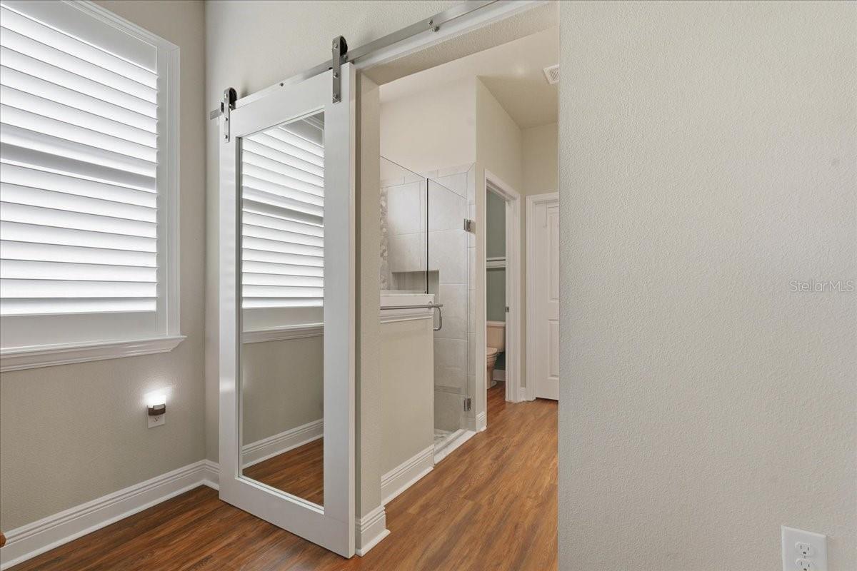 MIRRORED BARN DOOR LEADING INTO THE PRIMARY BATH & CLOSET!