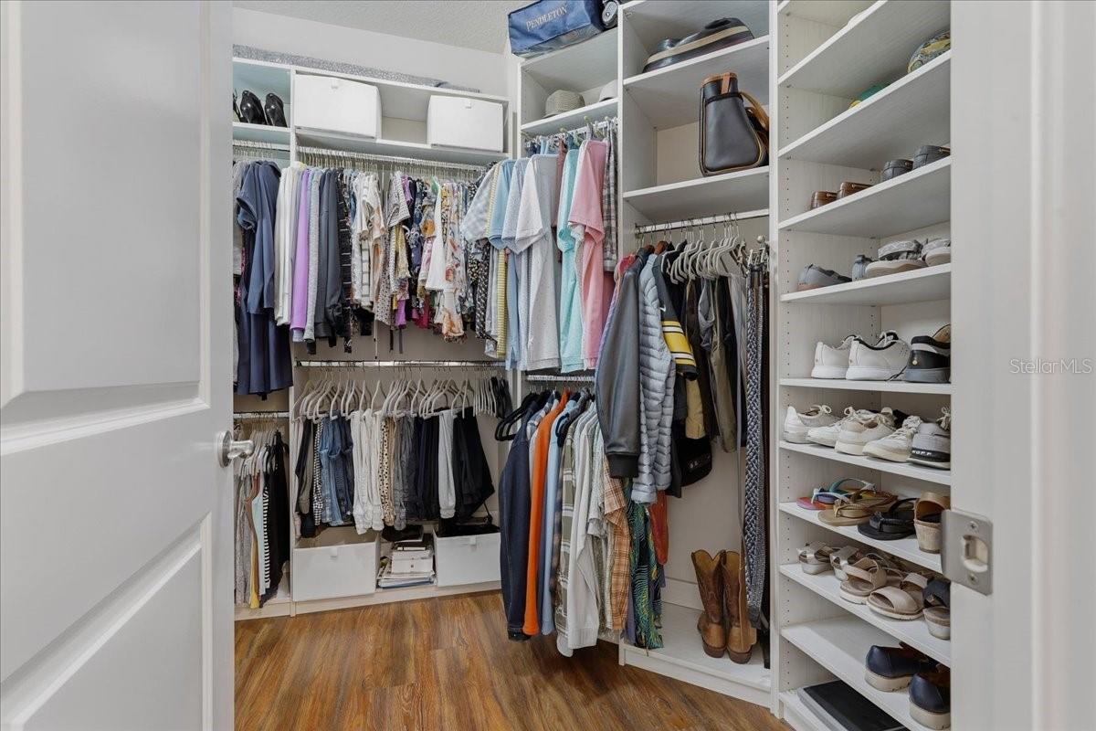 WALK IN CLOSET WITH CUSTOM BUILT-INS IN THE PRIMARY